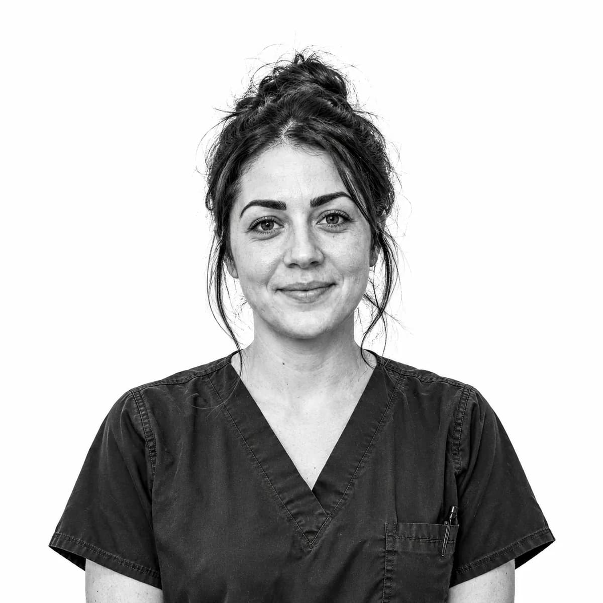 Nurse in scrubs with a calm, gentle smile